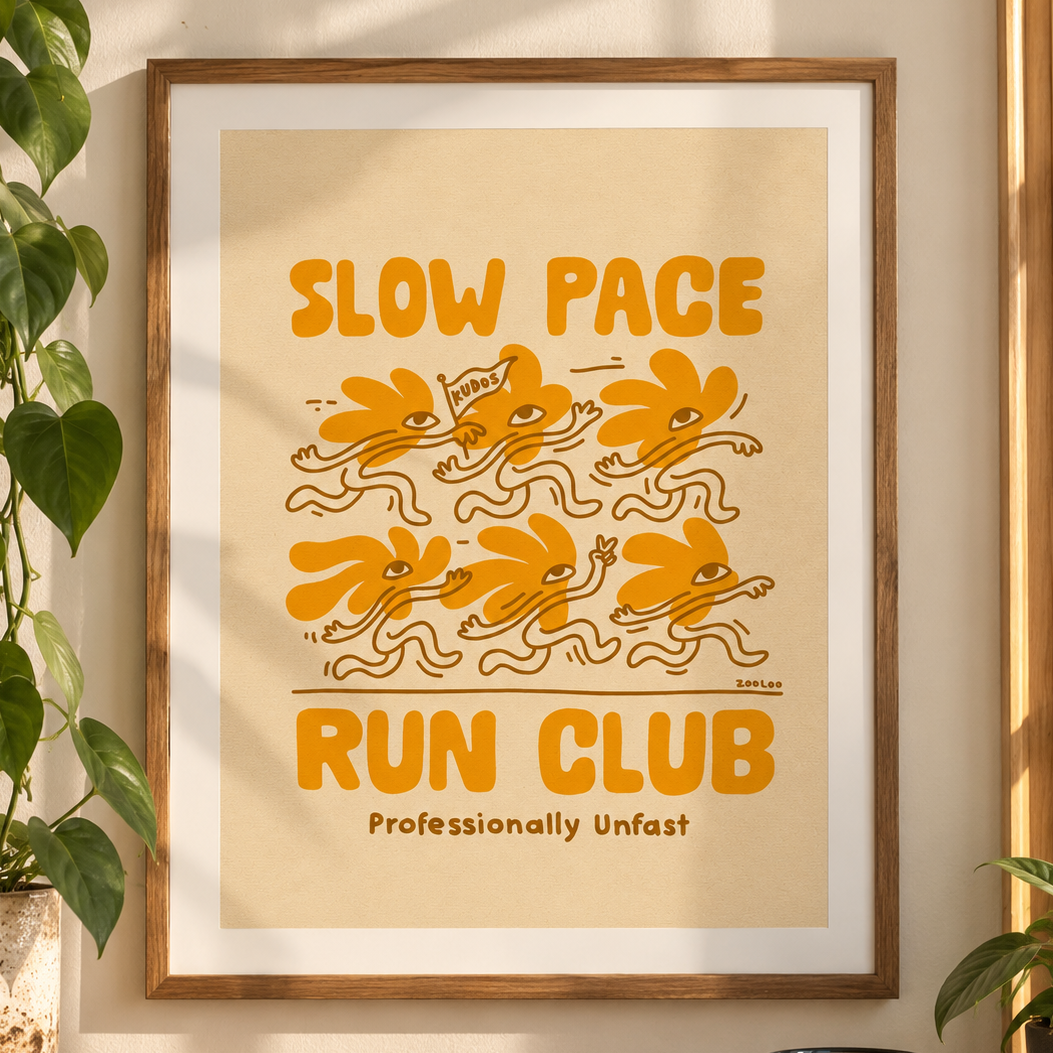 Framed Slow Pace Run Club art print with mustard-orange retro illustration of quirky runner characters and the tagline Professionally Unfast, by Zooloo Design